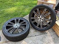 Two 24-inch VCT rims with Continental ExtremeContact tires placed on concrete outdoors, front and side visible.