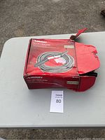Box of Husky 1/2 inch 50 foot drain auger placed on a white table with lot number card 80.