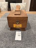 Closed wooden shoe server box with Kiwi shoe polish label on front.