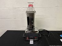 Front view of the Vita-Mix 3600+ blender showing chrome body, clear container with red label, and attached power cord.