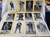 Shows front view of lot arranged on table, displaying 13 black and white 1940s-50s Toronto Maple Leafs hockey player photos mounted on beige backing.