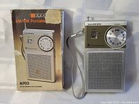 Lloyd's N703 AM/FM radio with original packaging, showing front of radio and box with model info.