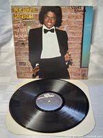 Black vinyl record disc with Epic record label in center displayed outside of its cardboard sleeve.