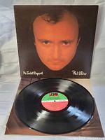 Photo of the vinyl LP record with the album cover opened and the record resting on it. Visible green and red label on the vinyl with the Atlantic logo and album details.