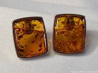 Front view of the amber earrings showing the rich amber color and natural inclusions set in sterling silver.