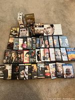 Photo showing the DVD lot with multiple DVD and Blu-ray cases including 'Unfaithful', 'Sin City', 'Australia', and others arranged on the floor.