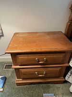 Photo of wood end table with two drawers, showing water damage and staining on top