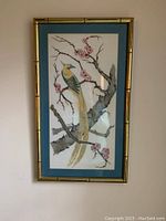 Full view of framed handmade pen on felt artwork showing a bird perched on a blooming branch with a blue mat and bamboo-style wood frame.