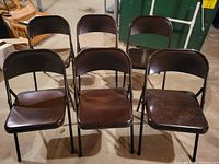 Photo of six brown aluminum metal folding chairs, all in good condition with no padding on seats.