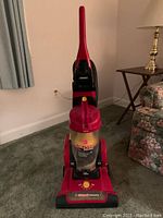 Red Hoover Elite Rewind upright vacuum cleaner shown standing on carpet, front view