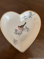Top-down view of the heart-shaped bone china tray showing detailed floral and bird artwork with gold leaf rim.