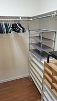 Closet space featuring plastic and velvet clothes hangers on a white hanging rod, along with two shoe storage units: a gray 4-tier rack and a wooden compartment organizer.