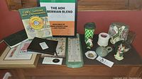 Overall view of the Irish inspired collectibles on wooden surface including framed prints, books, ceramic figurines, and glass items.