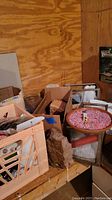 Wide shot of lot showing plastic crate with small items, various rocks, mineral display stand, wicker baskets, and boxes