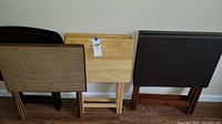 Photo showing four pairs of TV tables arranged side by side with different styles and finishes