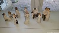 Overview of eight Willow Tree figurines arranged on a windowsill, showing full lot and display style.