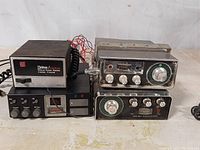 Photo showing two CB radio transceivers stacked, connected with power supply unit and controls visible