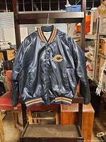 Front view of children's Chicago Bears black jacket with snap buttons, logo on chest, striped ribbed collar, cuffs, and waistband.