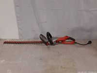 Full length image of the Black & Decker Hedge Hog 24-inch electric hedge trimmer, showing the blade, front handle and main body with power cord.