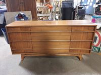Front view of walnut veneer buffet showing three recessed swing doors and integrated curved pulls