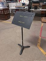 Front and angled view of the black Manhasset music stand showing size and text