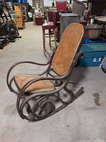 Side and angled view of bentwood cane rocking chair showing the curved rocker base and cane seat and backrest.