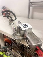 Close-up of metal cutting attachment on the Echo gas trimmer showing guard and blade mechanism.