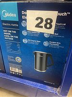 Photo of the Midea MEK17DW-18 electric kettle box showing key features and specifications