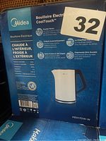 Midea electric kettle box detailing features such as double wall for insulation, CoolTouch technology, 1.7L capacity, and model number MEK17DW-W in white/blue.