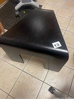 Side angle view showing the curved shape and smooth black finish with minor wear marks.