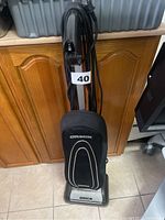 Front view of Oreck upright vacuum cleaner showing fabric bag with logo and attached cord.