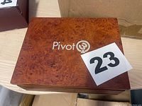Closed wood-finish box labeled 'Pivot' with wood grain texture.