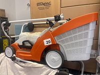 Photo of the Stihl electric lawnmower showing the side and rear with collection bag and handlebar.