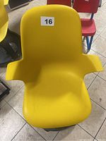 Front view of yellow ergonomic chair with armrests and black circular wheeled base