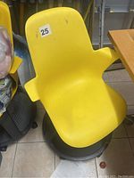 Yellow plastic chair with armrests on black rolling swivel base, shown from two angles.