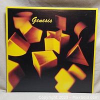Front cover of Genesis vinyl album showing abstract yellow shapes on black background with 'Genesis' in yellow text.