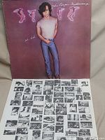 Front cover of John Cougar Mellencamp vinyl album Uh-Huh showing artist and album title with image of the artist standing.