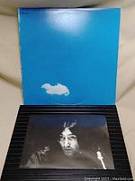 Front cover of vinyl record with blue sky and a white cloud design.