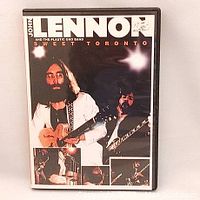 Front cover of the John Lennon and Plastic Ono Band Sweet Toronto DVD showing John Lennon holding a guitar with concert snapshots.