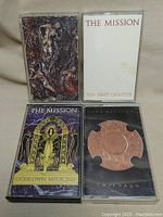 Four cassette tapes by The Mission laid flat to show covers including The First Chapter, Gods Own Medicine, Children, and one artistic cover