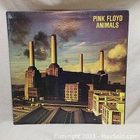 Front cover of Pink Floyd Animals vinyl album with industrial power station image and title in yellow text