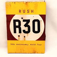 Front cover of Rush R30 30th Anniversary World Tour DVD box with yellow and brown design.