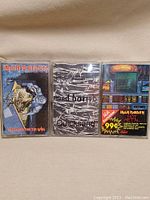 Front view of three cassette tapes in cases, showing distinct cover art, arranged side-by-side.