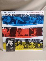 Front cover of The Police Synchronicity vinyl album with cassette tape placed on top.