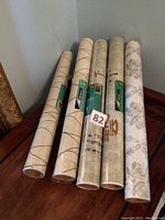 Five rolls of wallpaper standing upright showing various designs and labels