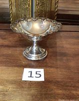Side view of the English sterling silver pedestal bowl highlighting the ornate scalloped edges and polished surface.