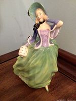 Royal Doulton Autumn Breezes figurine in left profile showing flowing skirt and basket detail.
