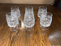 Six vintage short stemmed crystal cups arranged in two rows on a wooden table, showing overall set and detailing on the crystal.