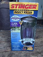 Box showing Stinger Outdoor Insect Killer branding and features including advanced black light technology and coverage area of 1/2 acre (2025 sq. ft.)