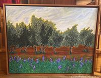 Frontal view of the framed painting showing landscape with trees and purple flowers.